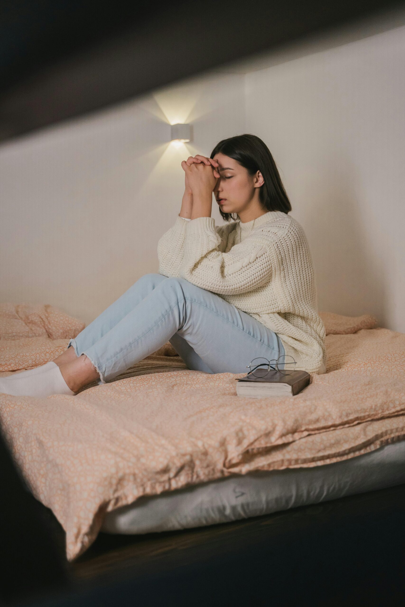 A woman praying on her bed