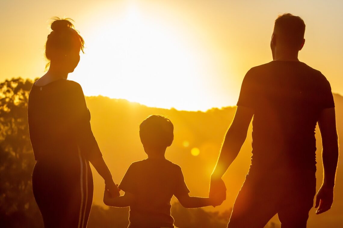 Family holding hands in sunset