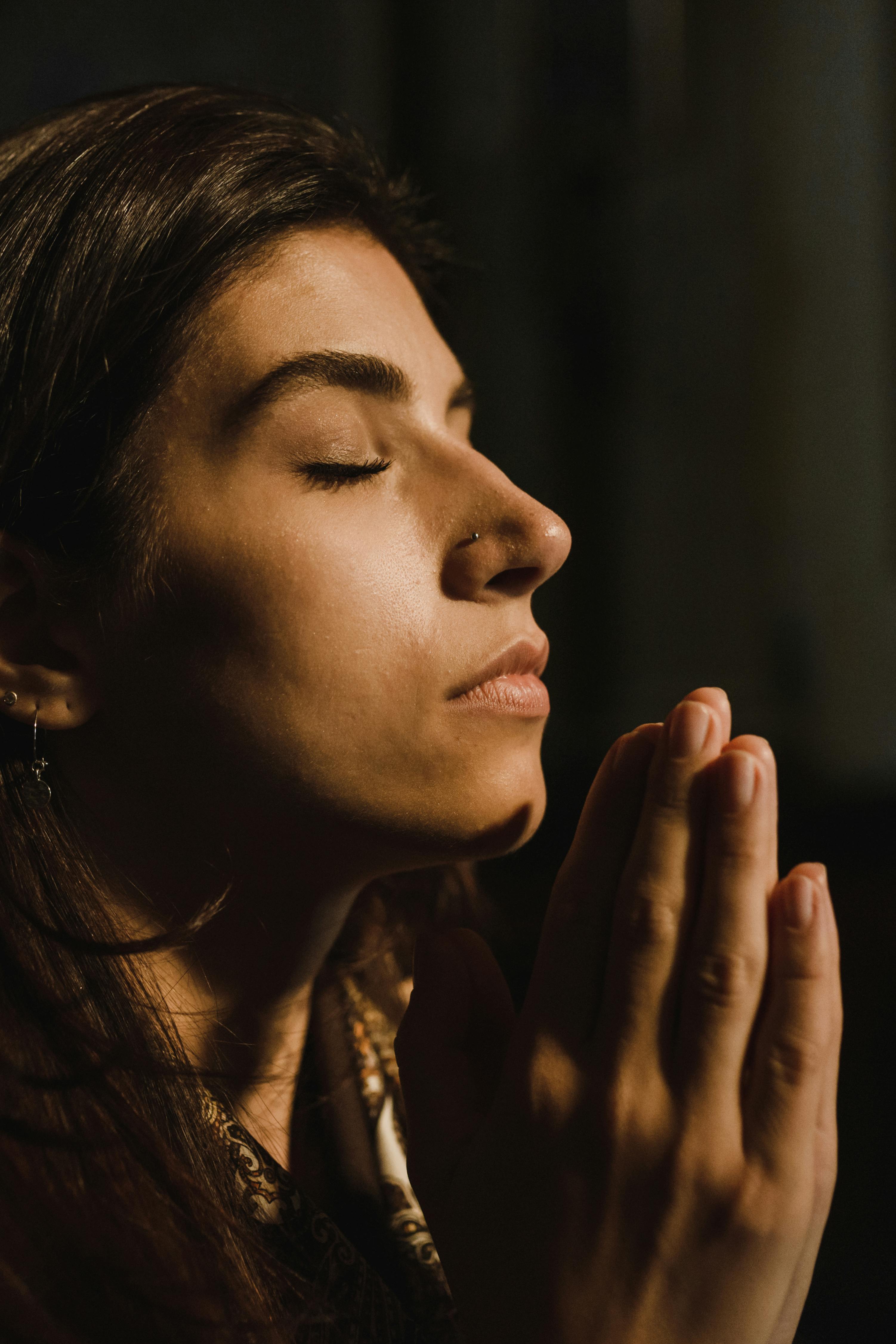 a woman praying in the dark